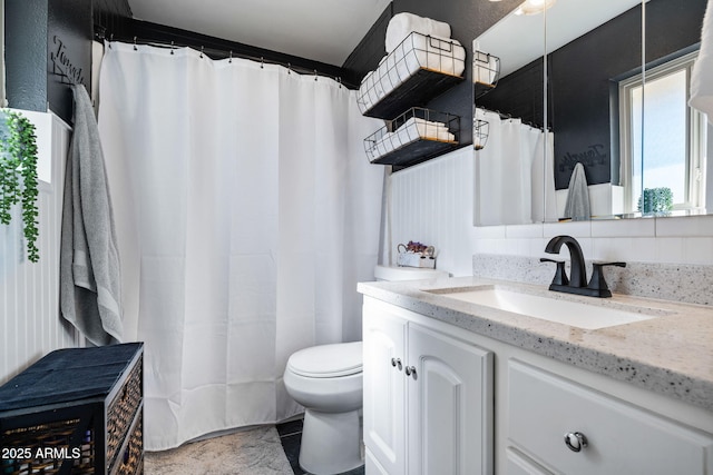 bathroom featuring tasteful backsplash, toilet, and vanity