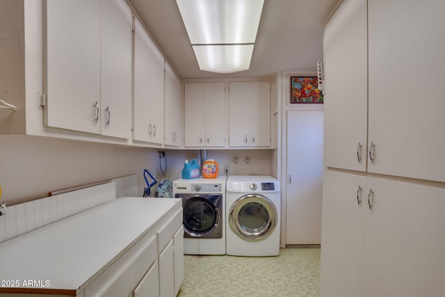 clothes washing area with cabinets and washing machine and dryer