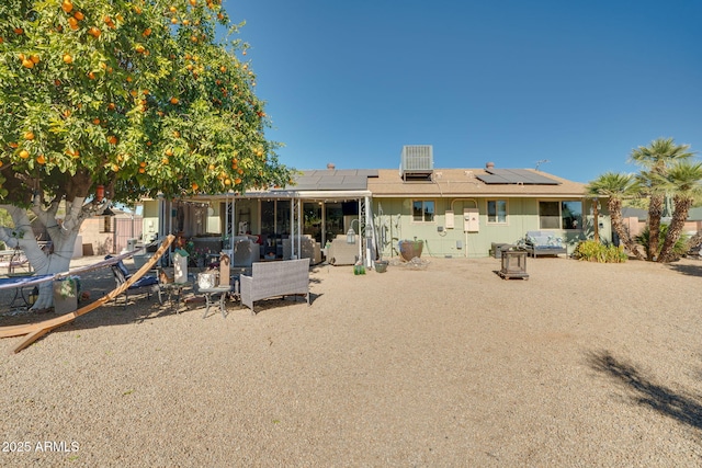 back of house with central air condition unit, solar panels, and a patio area