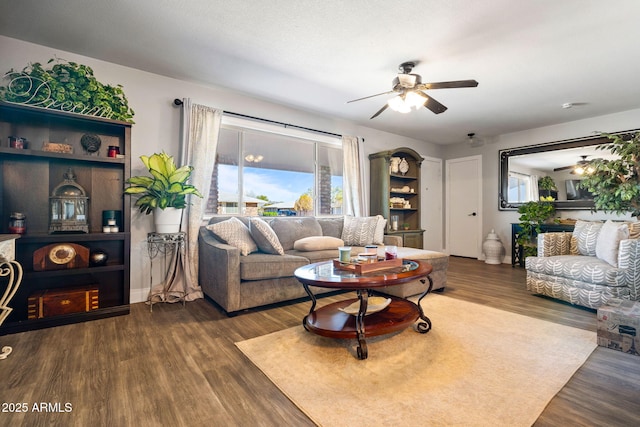 living room featuring ceiling fan and dark hardwood / wood-style floors