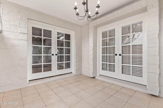 interior space featuring light tile patterned floors, french doors, and a chandelier