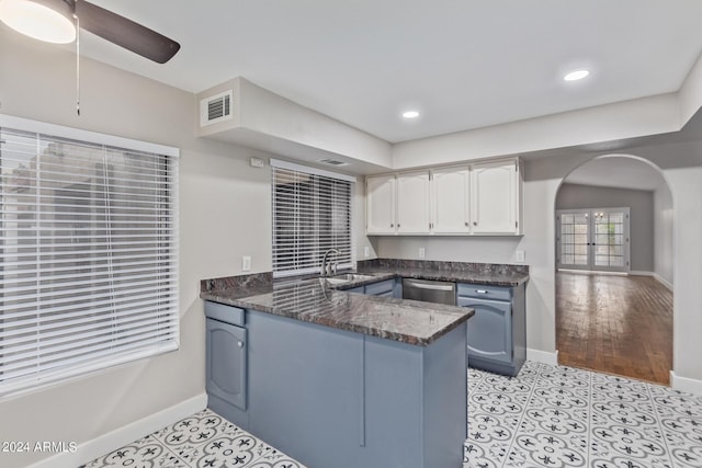 kitchen featuring dishwasher, white cabinets, sink, dark stone countertops, and kitchen peninsula