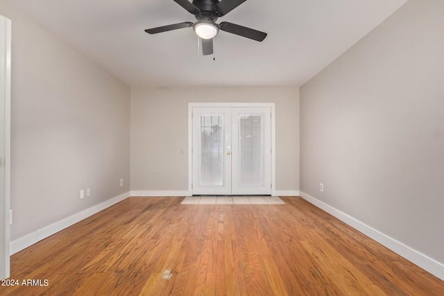 unfurnished room with ceiling fan, light hardwood / wood-style floors, and french doors