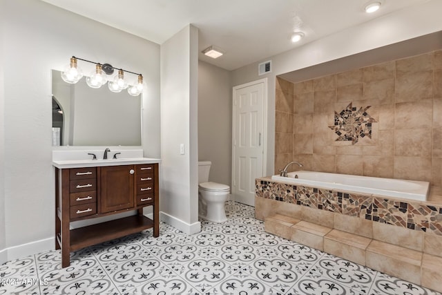 bathroom featuring tile patterned floors, vanity, toilet, and tiled tub