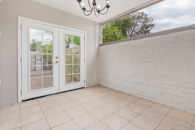 entryway featuring an inviting chandelier, light tile patterned floors, and french doors