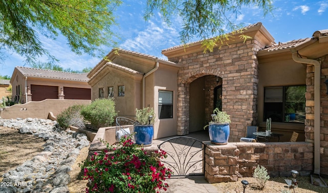 7130 E Saddleback St Unit 58, Mesa, AZ 85207 - view of front facade with a tile roof, stucco siding, a garage, and stone siding