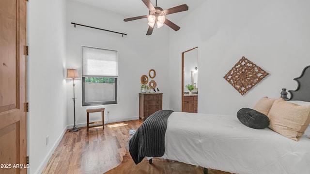 7130 E Saddleback St Unit 58, Mesa, AZ 85207 - bedroom featuring wood finished floors, baseboards, a high ceiling, ensuite bath, and ceiling fan
