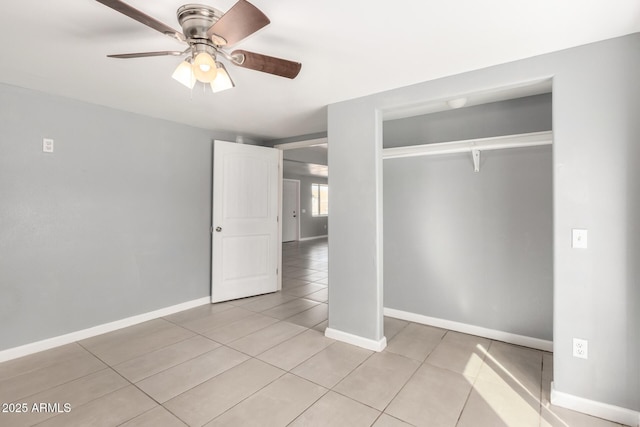 unfurnished bedroom featuring light tile patterned floors, ceiling fan, baseboards, and a closet