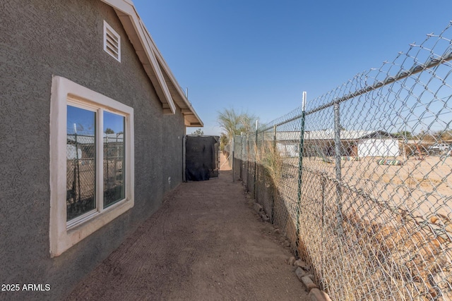 view of home's exterior with fence and stucco siding