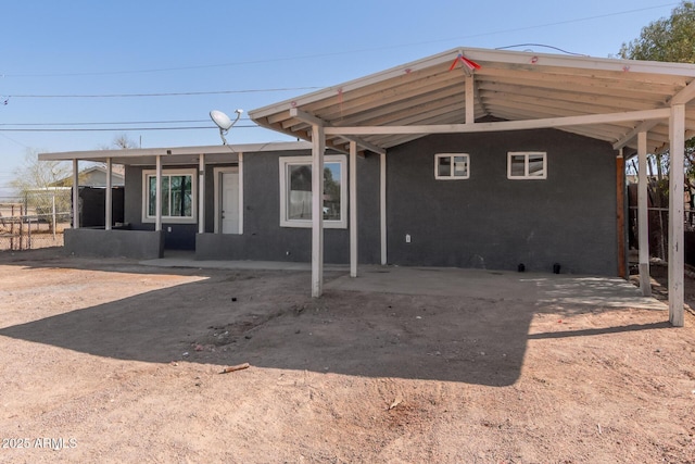 back of property featuring fence and stucco siding