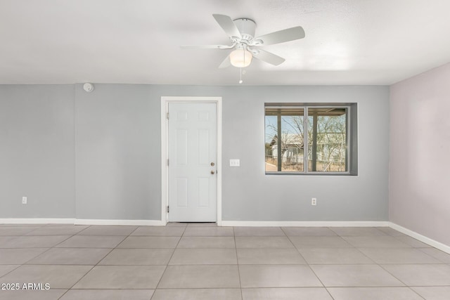 empty room featuring ceiling fan, baseboards, and light tile patterned floors