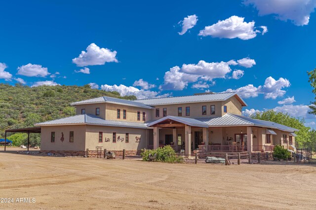 back of house featuring a carport and a porch