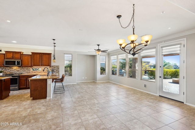 kitchen featuring pendant lighting, a kitchen breakfast bar, ornamental molding, light stone counters, and stainless steel appliances