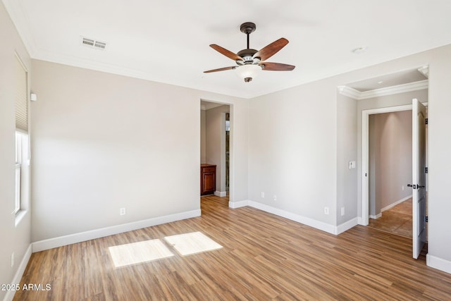 empty room featuring crown molding, ceiling fan, and light wood-type flooring