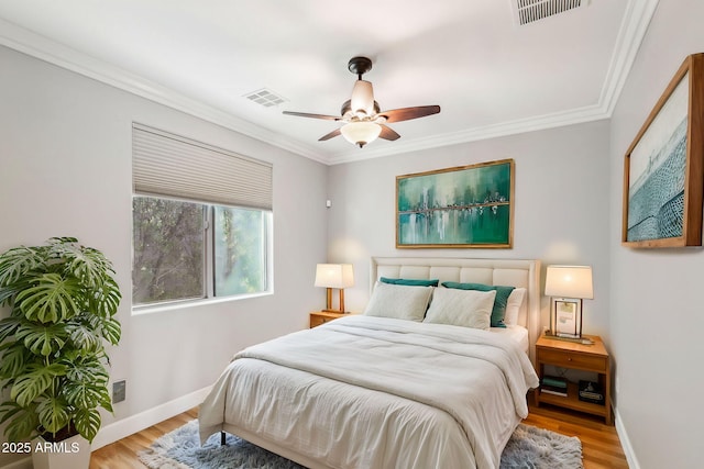 bedroom with ornamental molding, ceiling fan, and light hardwood / wood-style floors