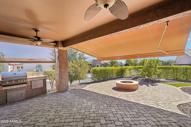 view of patio with area for grilling, a fire pit, and ceiling fan