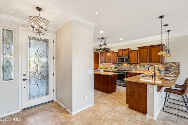 kitchen with hanging light fixtures, stainless steel appliances, kitchen peninsula, and a kitchen bar