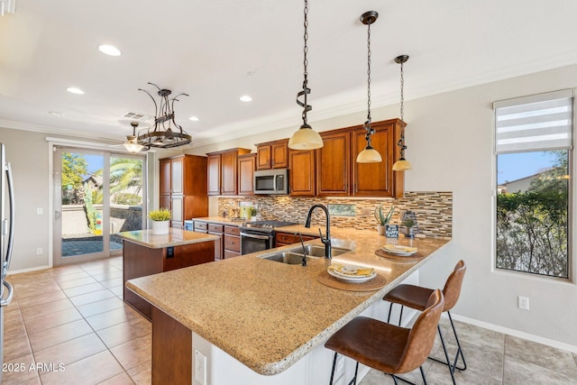 kitchen with sink, a breakfast bar, stainless steel appliances, ornamental molding, and kitchen peninsula