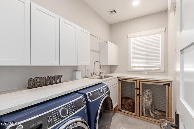 laundry area featuring washer and dryer, sink, and cabinets