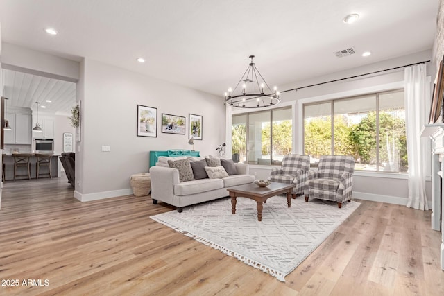 living room featuring an inviting chandelier and light wood-type flooring