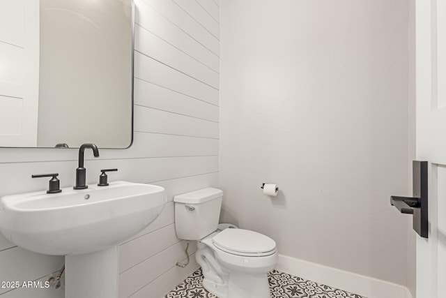 bathroom with toilet, tile patterned flooring, and sink