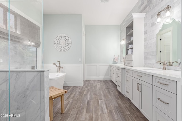 bathroom featuring hardwood / wood-style flooring, a tub to relax in, and vanity