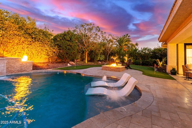 pool at dusk featuring a patio, a fire pit, and pool water feature