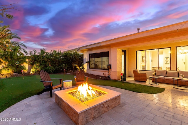 patio terrace at dusk with an outdoor living space with a fire pit