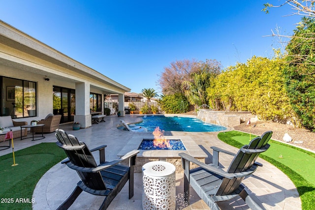 view of swimming pool with pool water feature, a patio area, and a fire pit