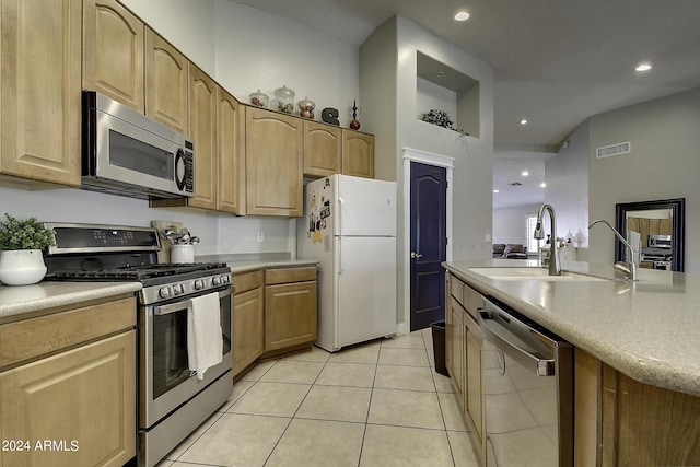 kitchen featuring appliances with stainless steel finishes, sink, light tile patterned floors, and light brown cabinetry