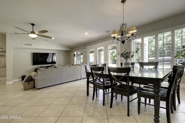 dining area featuring french doors, ceiling fan with notable chandelier, vaulted ceiling, and light tile patterned floors