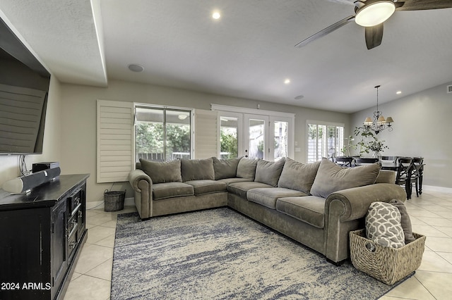 living room with light tile patterned floors, ceiling fan with notable chandelier, and french doors