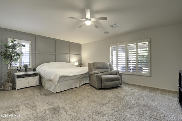 bedroom with multiple windows, light carpet, and ceiling fan