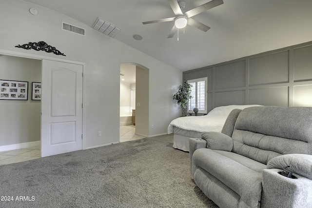 bedroom with lofted ceiling, light carpet, ceiling fan, and ensuite bathroom