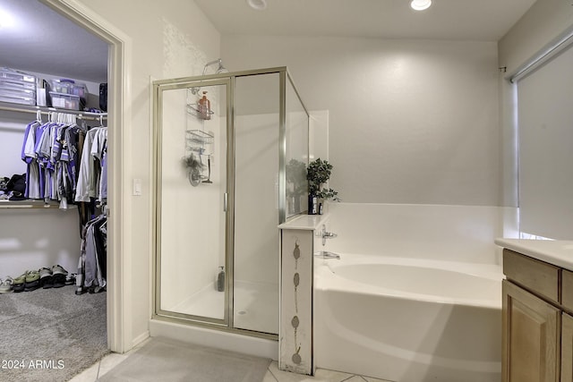 bathroom with tile patterned flooring, shower with separate bathtub, and vanity