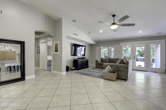 living room with lofted ceiling, light tile patterned floors, and ceiling fan