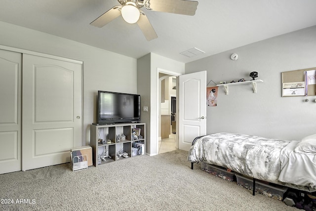 carpeted bedroom with ceiling fan and a closet