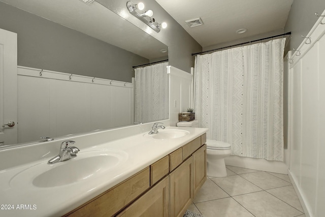 full bathroom with vanity, shower / bathtub combination with curtain, tile patterned floors, and toilet