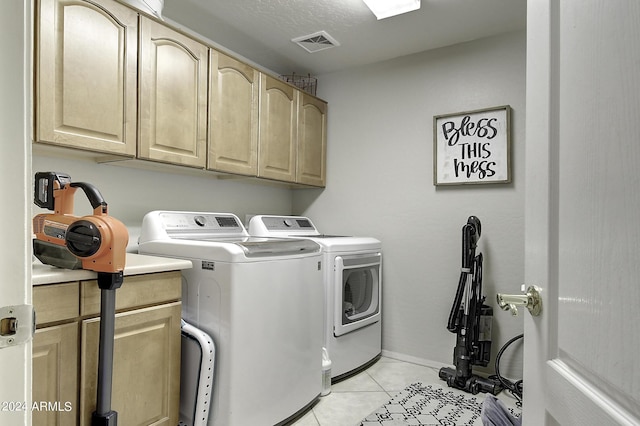 laundry area with light tile patterned flooring, cabinets, separate washer and dryer, and a textured ceiling