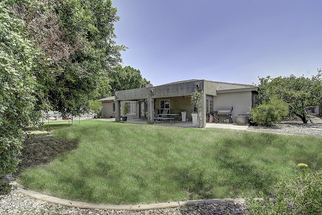 back of property with a patio and a lawn