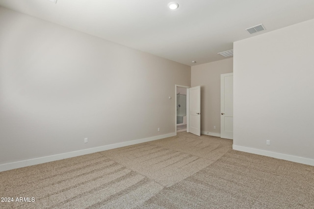 spare room featuring light colored carpet