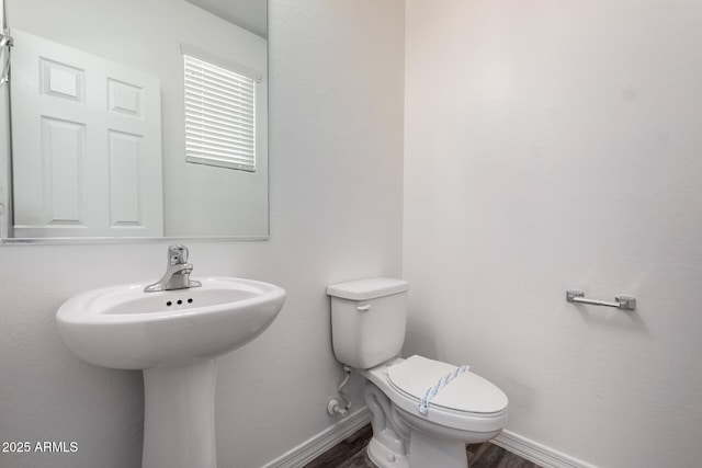 917 E Agua Fria Ln, Avondale, AZ 85323 - bathroom with toilet, wood finished floors, baseboards, and a sink
