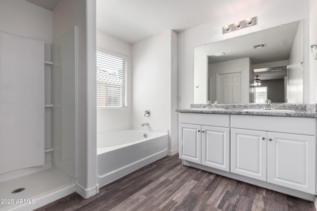 917 E Agua Fria Ln, Avondale, AZ 85323 - bathroom featuring double vanity, ceiling fan, a garden tub, wood finished floors, and baseboards