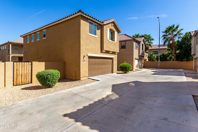 917 E Agua Fria Ln, Avondale, AZ 85323 - view of side of property featuring stucco siding, concrete driveway, an attached garage, and a tiled roof
