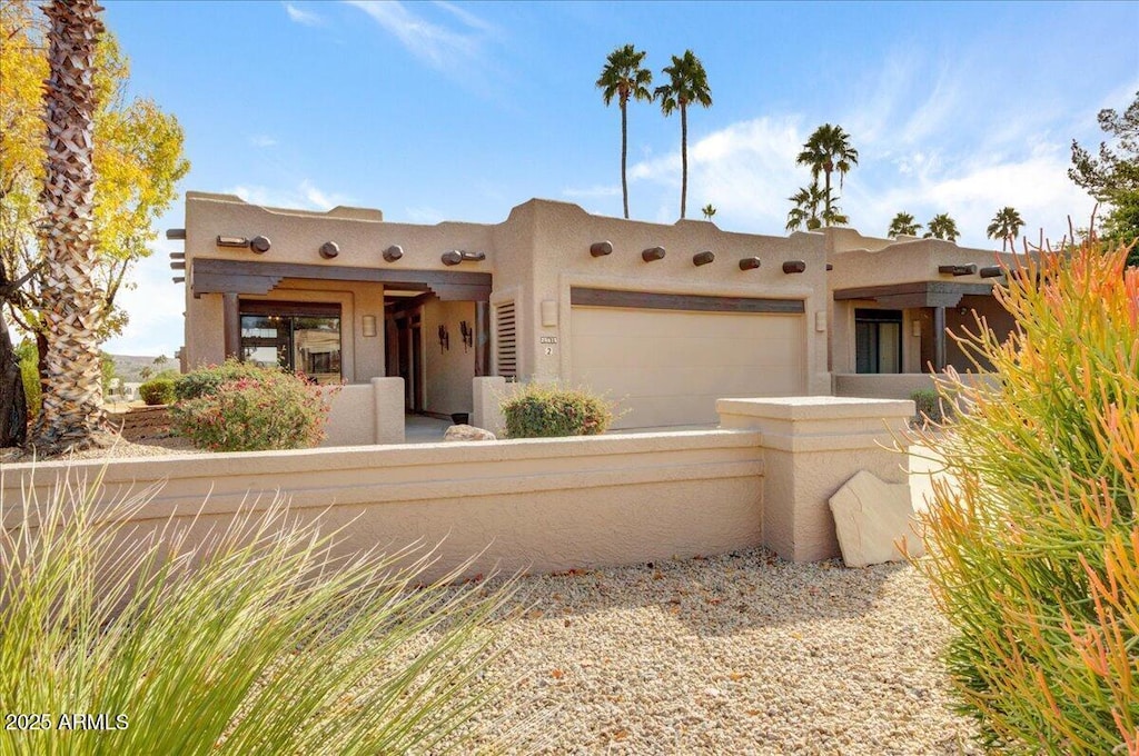 pueblo revival-style home featuring a garage