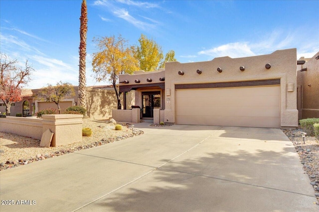 pueblo revival-style home with a garage