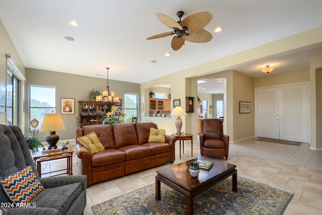 living room with ceiling fan with notable chandelier and light tile patterned flooring