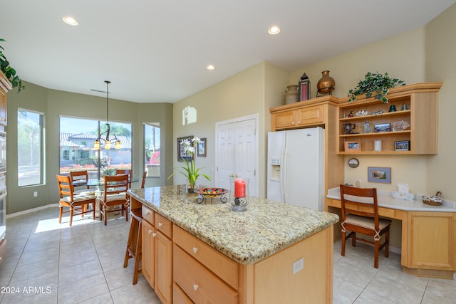 kitchen with pendant lighting, a center island, light tile patterned flooring, and white fridge with ice dispenser