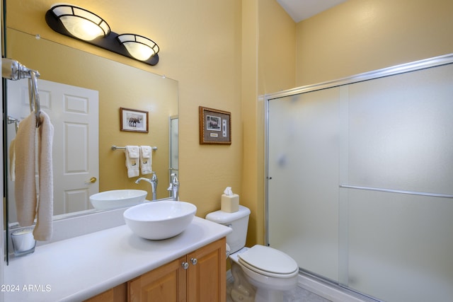 bathroom featuring vanity, a shower with shower door, and toilet