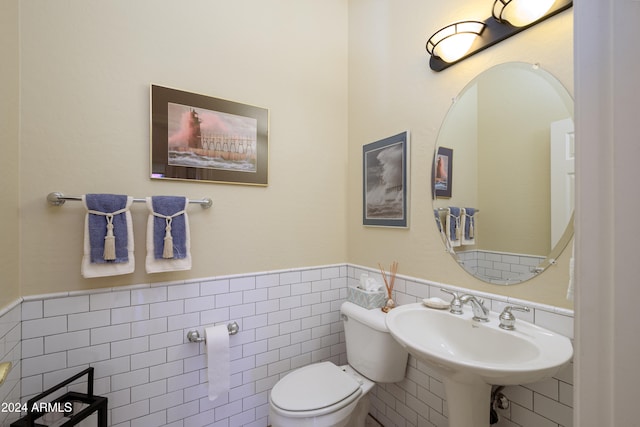 bathroom featuring sink, tile walls, and toilet